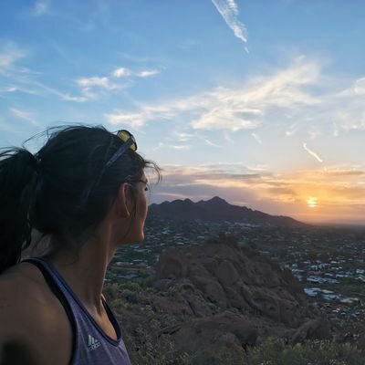 Janel looking out over a valley at sunrise.